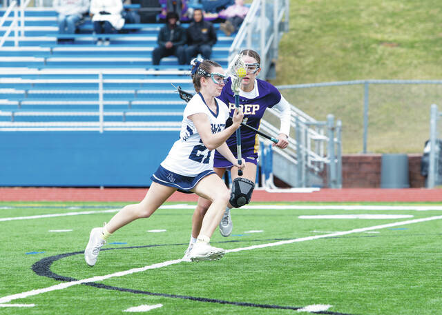 131404458_web1_250322ahsp--59-of-31-
Kiera Crowell (21), of Abington Heights, drives past a Scranton Prep defender.
Buck Norton-Jennings | For Abington Journal