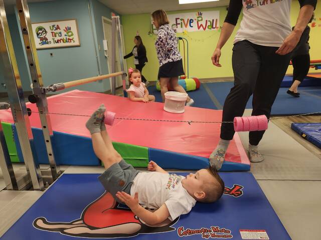 <p>2-year-old Ethan, son of USA Tiny Tumblers owner Emilia McCormich, demonstrates how to move objects along a line, using your feet only.</p>
<p>Mary Therese Biebel | Abington Journal</p>