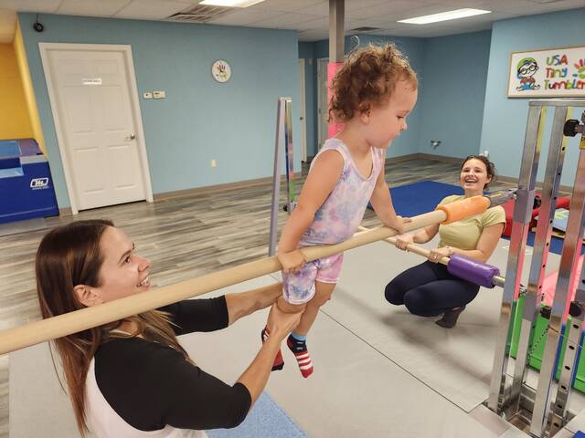 <p>Gia Fasciana, soon to turn 3, gets used to working on a horizontal bar, with help from teacher Emiliia McCormick at USA Tiny Tumblers in South Abington Township. Looking on is Gia’s mother, Gabby.</p>
<p>Mary Therese Biebel | Abington Journal</p>